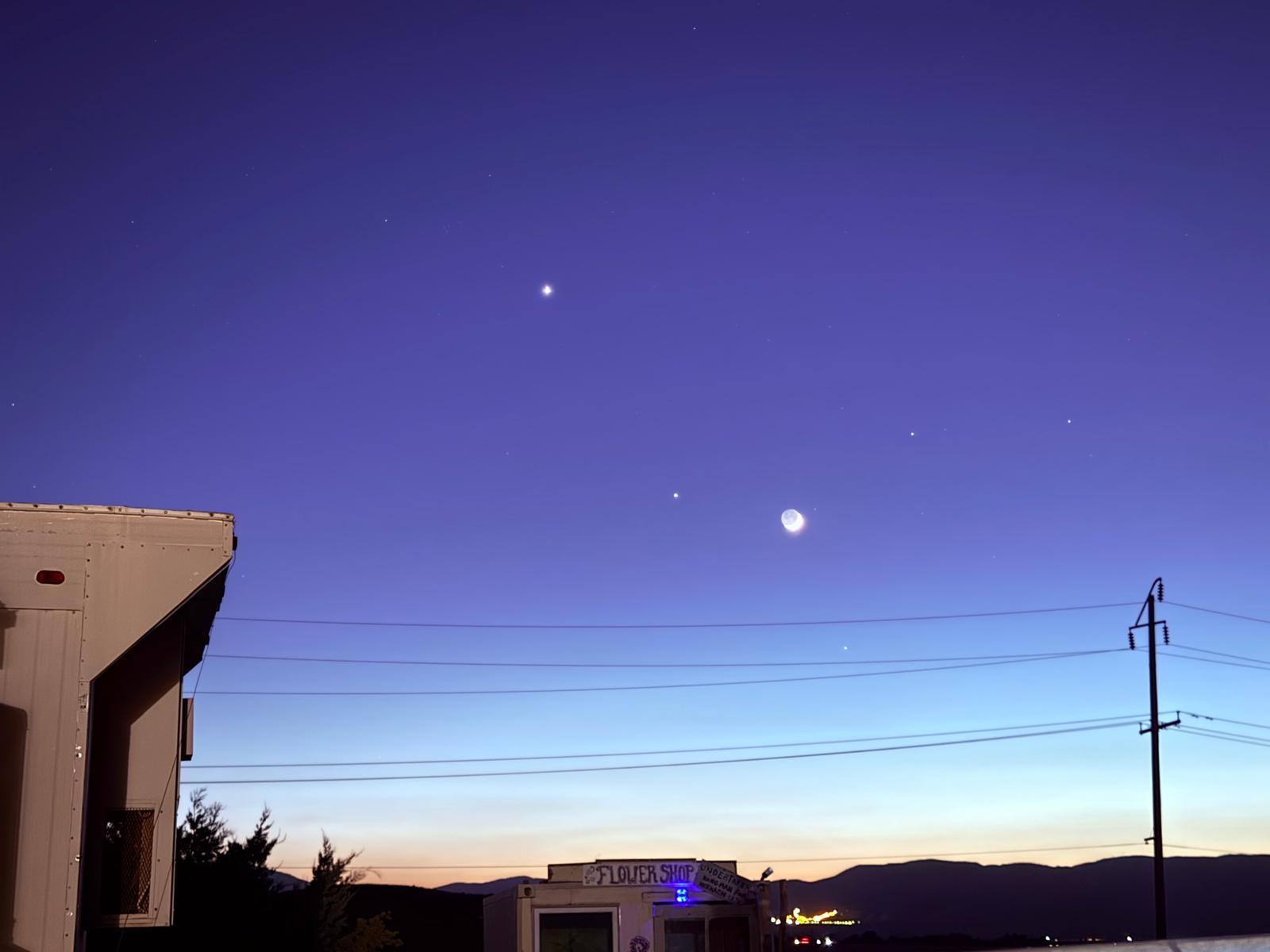 The moon rising in a violet sky over the town at nightfall
