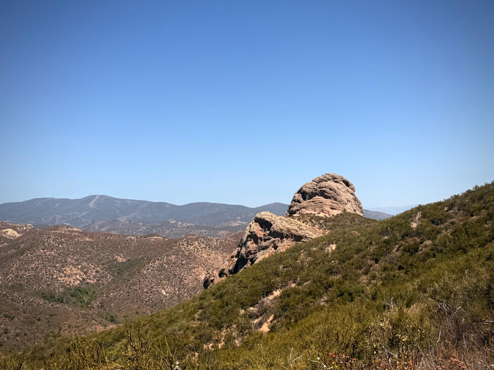 A granite outcrop standing over the ridgelines above the valley