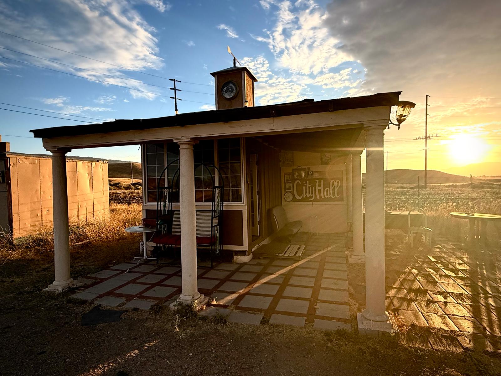 The city hall porch with the sun dropping behind the power lines
