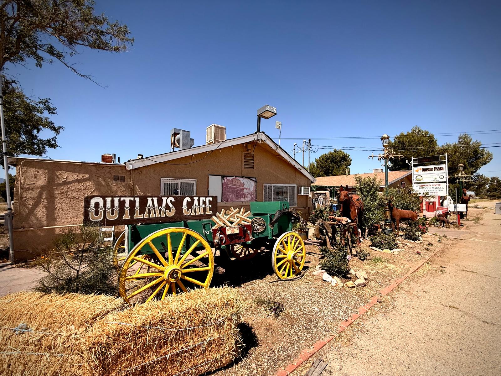 The Outlaws Cafe sign and an old wagon out front